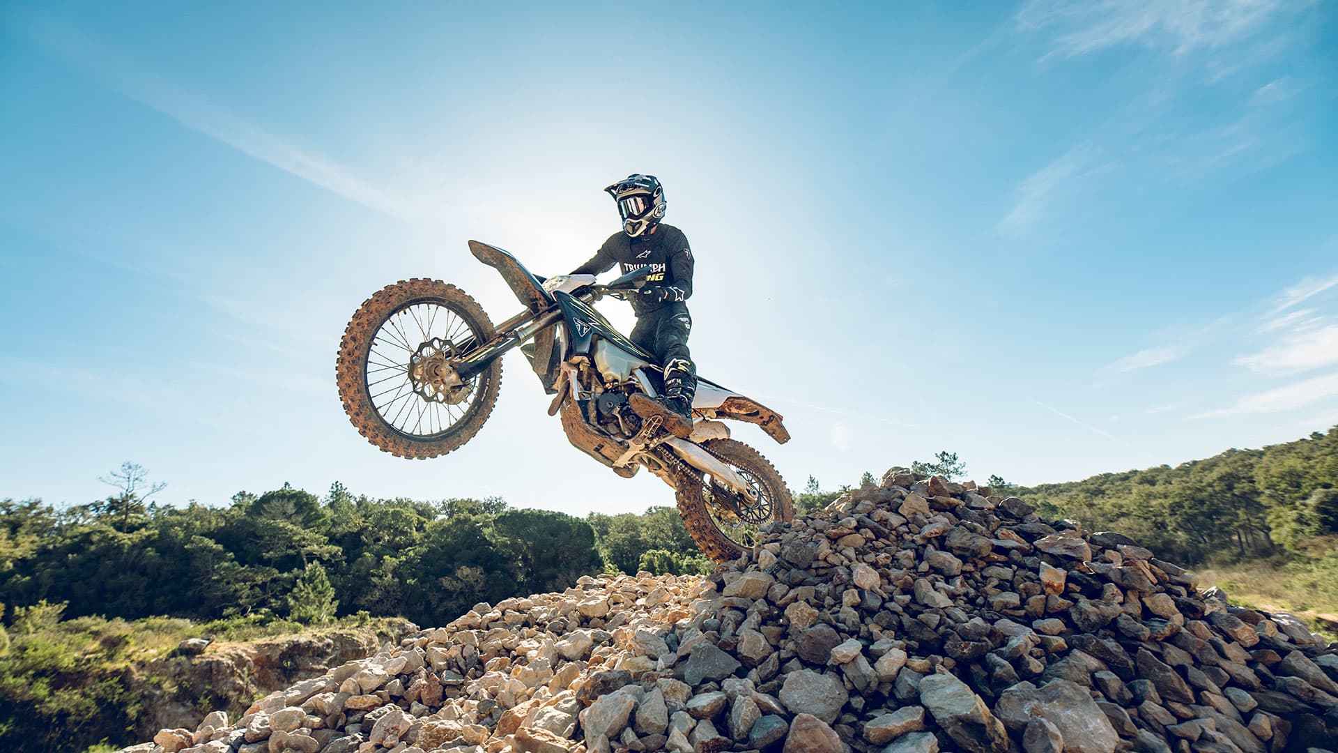 Triumph TF 250-E riding shot over rocks